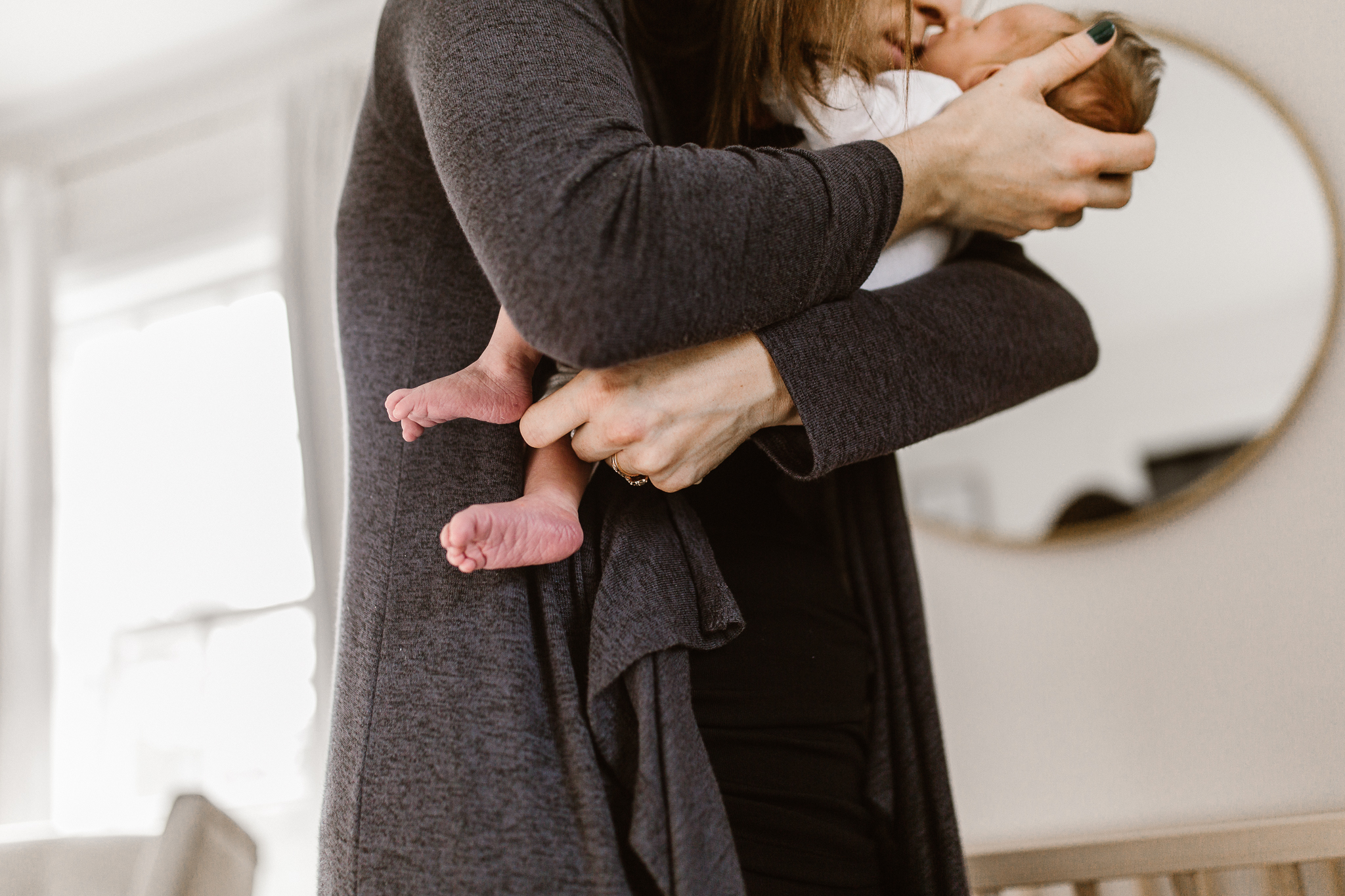 Mother cradling her baby in her arms and kissing his face.